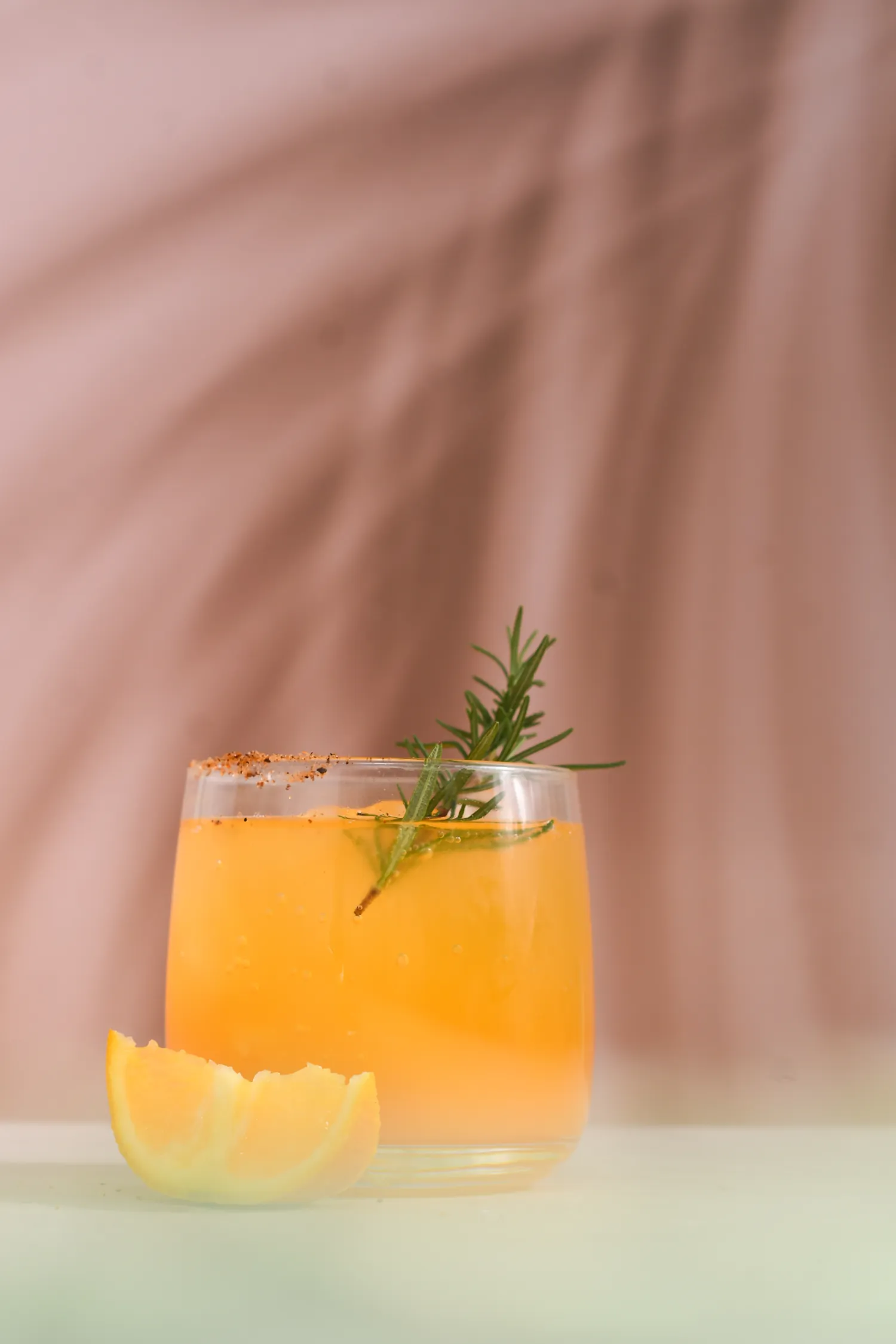 Mezcal servido en coctel con romero y naranja
